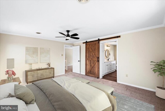 carpeted bedroom featuring crown molding, ceiling fan, connected bathroom, and a barn door