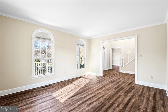 empty room featuring crown molding and dark hardwood / wood-style flooring