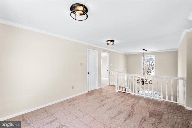 unfurnished room featuring ornamental molding, carpet flooring, and a notable chandelier