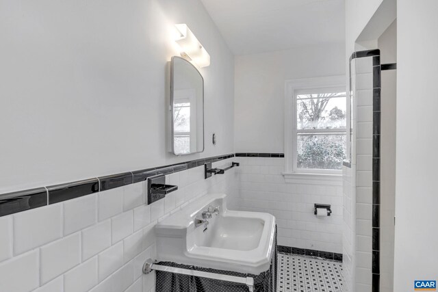 bathroom with sink and tile walls