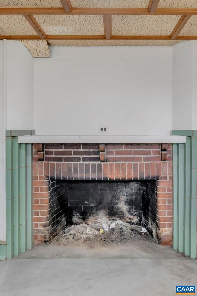 interior details with concrete flooring and a brick fireplace