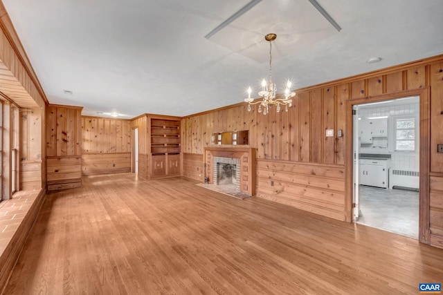 unfurnished living room with ornamental molding, radiator, and light hardwood / wood-style floors