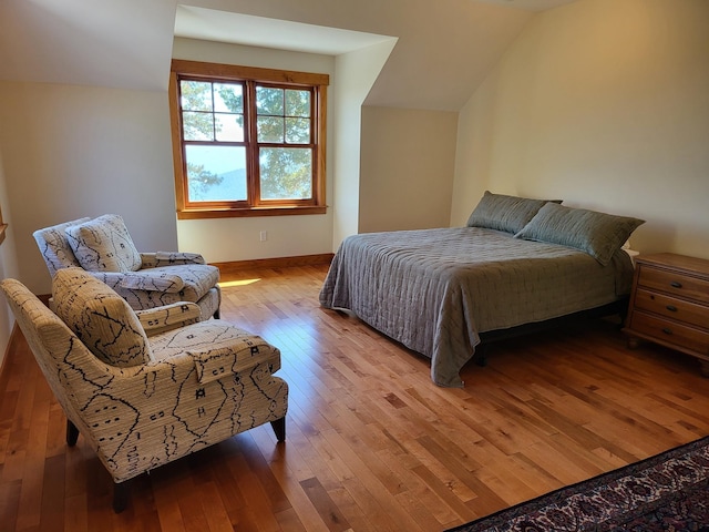 bedroom featuring light hardwood / wood-style flooring and vaulted ceiling