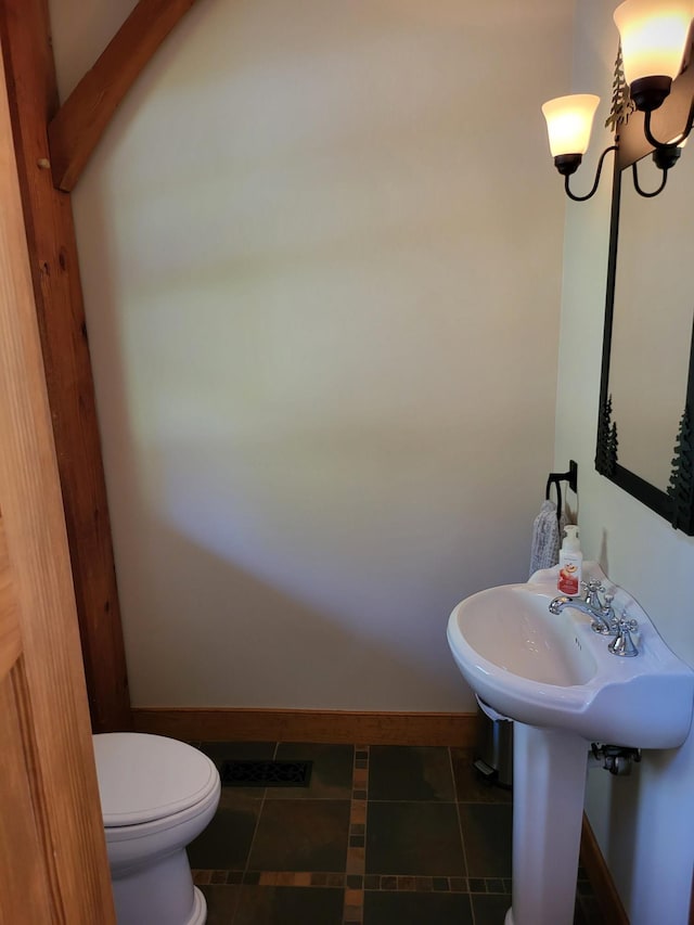 bathroom with an inviting chandelier and toilet