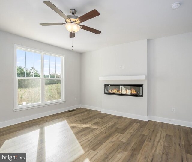 unfurnished living room with hardwood / wood-style flooring and ceiling fan