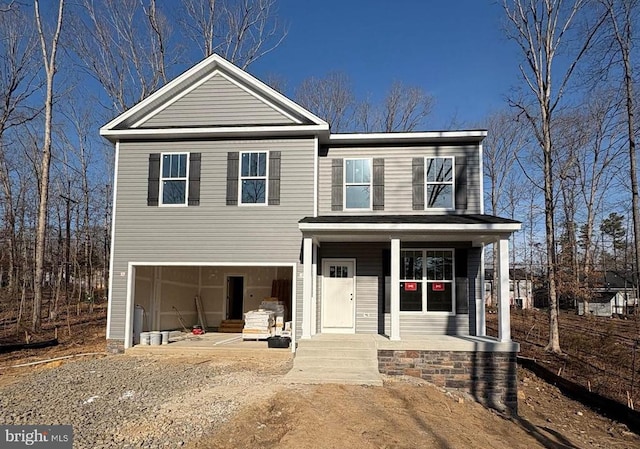 traditional home featuring a garage, a porch, and driveway