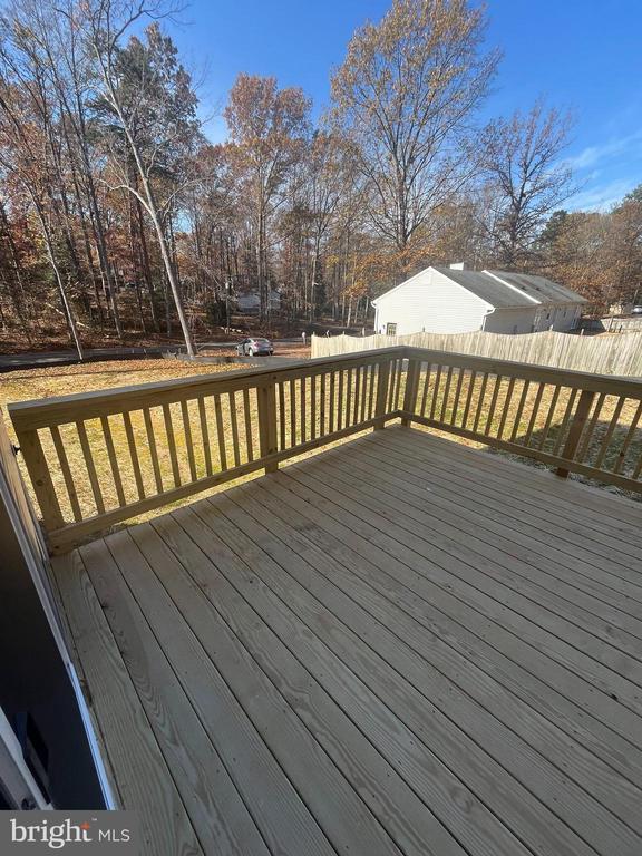 wooden terrace with a lawn