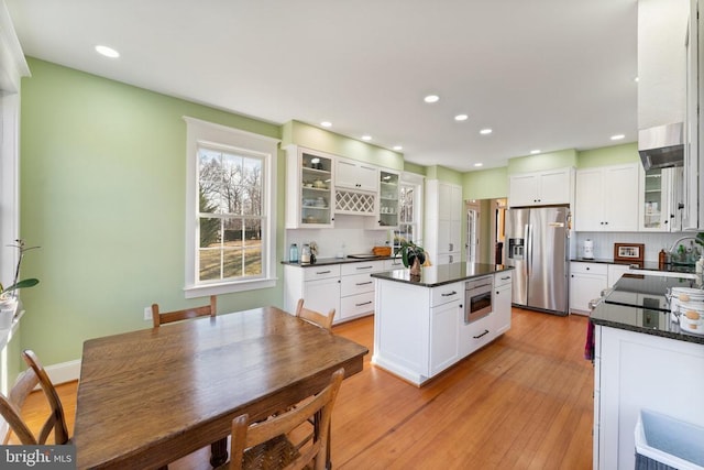 kitchen with a kitchen island, light wood-type flooring, white cabinets, and appliances with stainless steel finishes