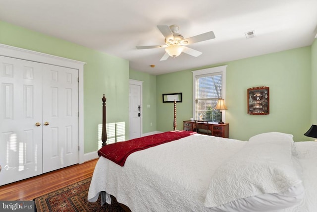 bedroom with hardwood / wood-style flooring, ceiling fan, and a closet