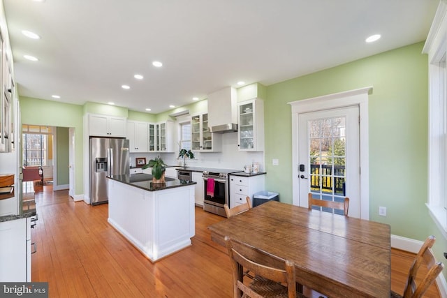 kitchen with sink, appliances with stainless steel finishes, a center island, white cabinets, and light wood-type flooring