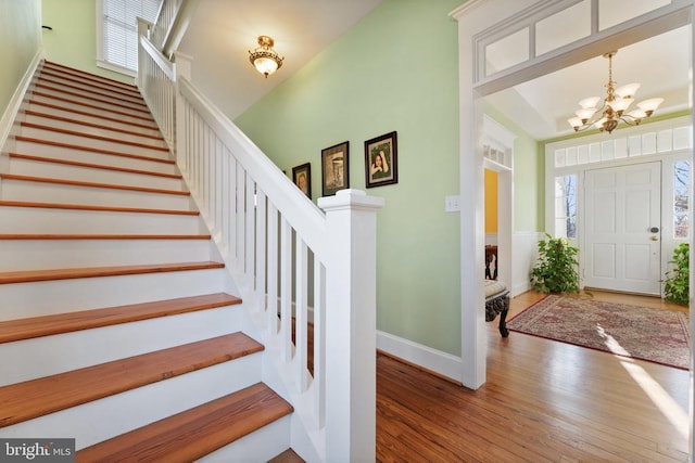 entrance foyer with wood-type flooring and an inviting chandelier