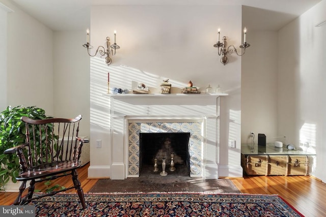 living room with a high end fireplace and wood-type flooring