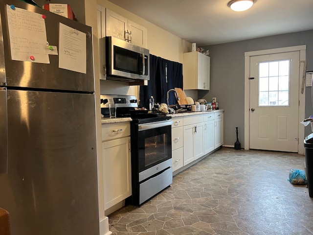 kitchen featuring stainless steel appliances and white cabinets
