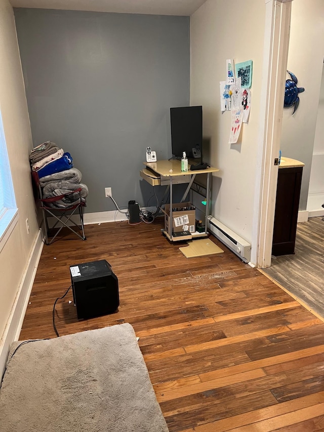 office area featuring wood-type flooring and a baseboard heating unit