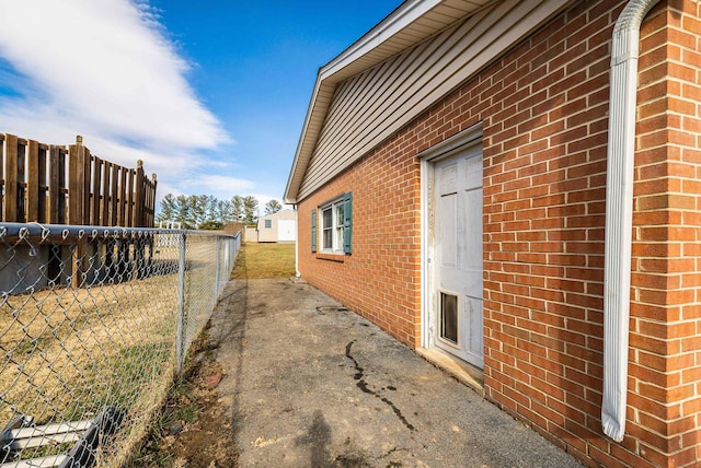 view of home's exterior with fence and brick siding