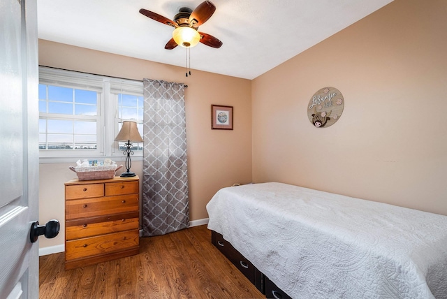 bedroom featuring dark wood-type flooring, baseboards, and a ceiling fan