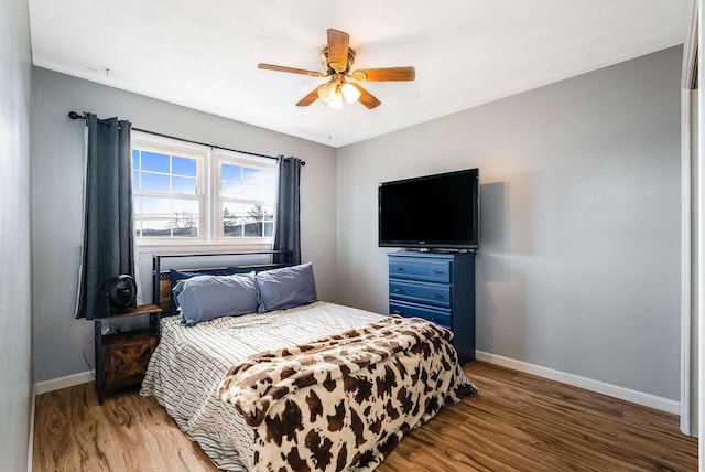 bedroom featuring light wood-style floors, baseboards, and a ceiling fan