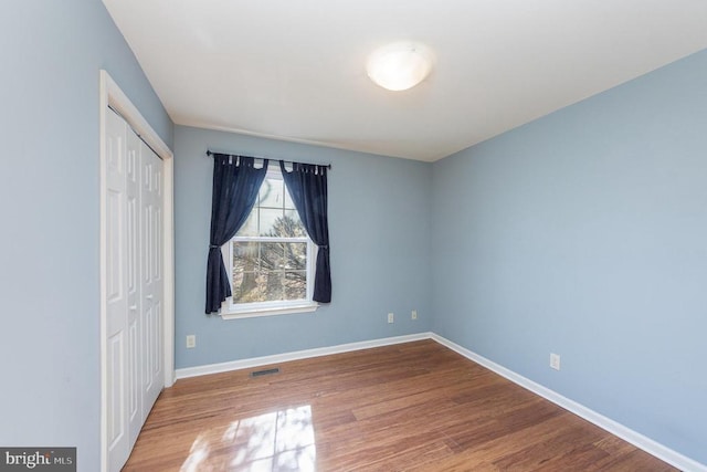 unfurnished bedroom with hardwood / wood-style floors and a closet