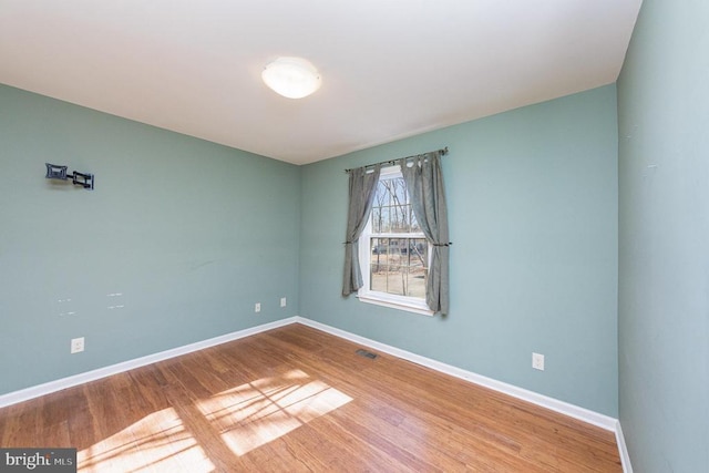 unfurnished room with hardwood / wood-style flooring