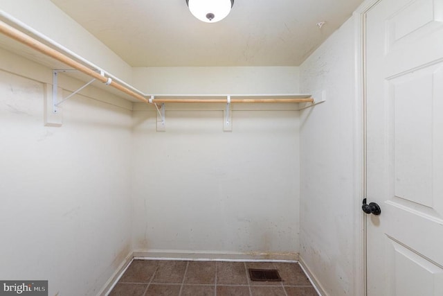 spacious closet featuring dark tile patterned floors