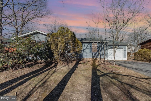 ranch-style house with a garage and a yard