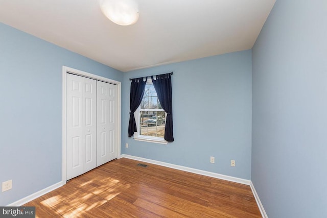 unfurnished bedroom with wood-type flooring and a closet