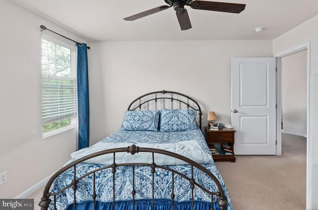 carpeted bedroom with baseboards, multiple windows, and a ceiling fan