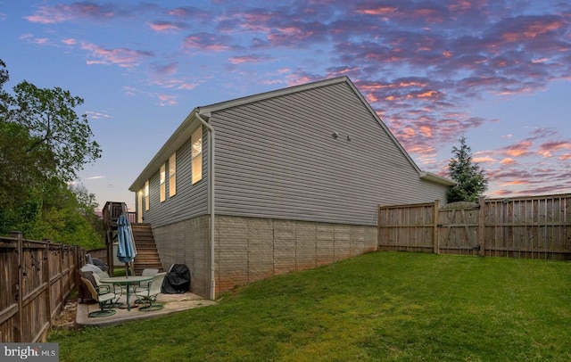 view of property exterior with a lawn, a fenced backyard, and a patio area