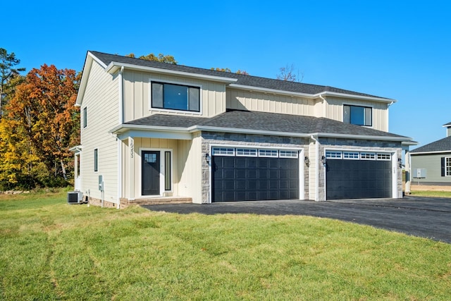 view of front of home with a garage, central AC, and a front yard