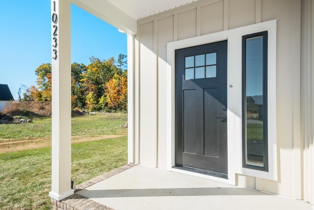 view of exterior entry with a lawn