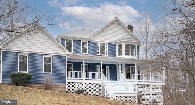 view of front of house with covered porch and a chimney