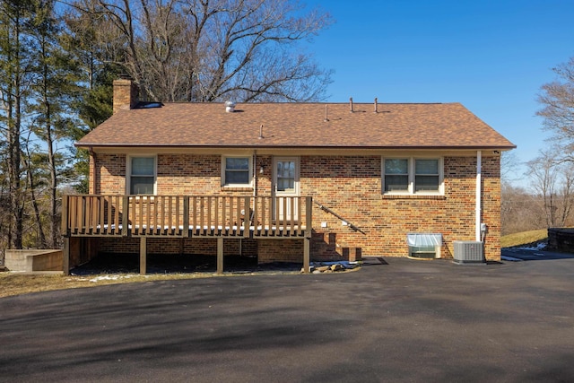 rear view of property featuring central AC and a wooden deck