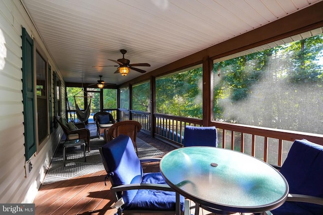 sunroom with ceiling fan and outdoor dining area