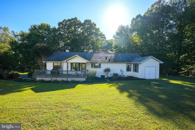 rear view of house featuring a wooden deck and a lawn