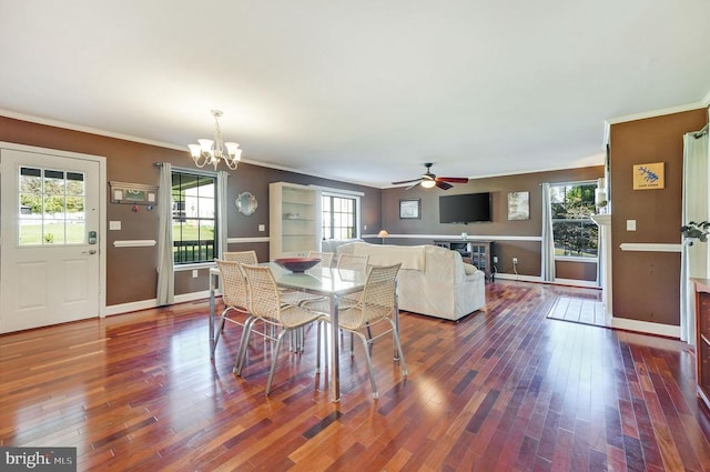 dining room featuring ceiling fan with notable chandelier, ornamental molding, baseboards, and dark wood finished floors