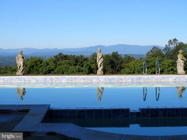 view of swimming pool with a mountain view