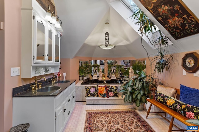 bathroom featuring vanity and vaulted ceiling with skylight