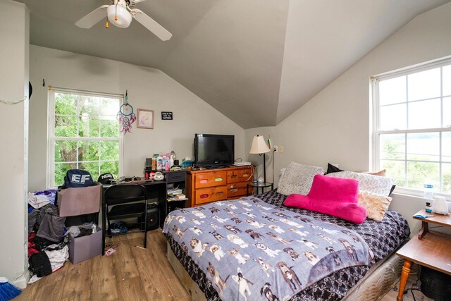 bedroom featuring hardwood / wood-style flooring, ceiling fan, lofted ceiling, and multiple windows