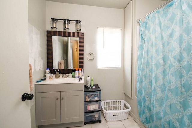 bathroom with tile patterned flooring, vanity, and walk in shower