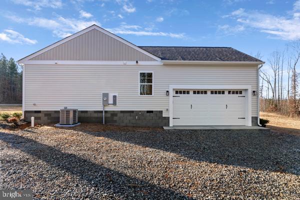 view of side of home featuring a garage and cooling unit