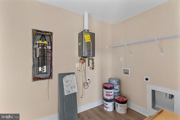 laundry area featuring hardwood / wood-style floors, water heater, washer hookup, electric panel, and hookup for an electric dryer