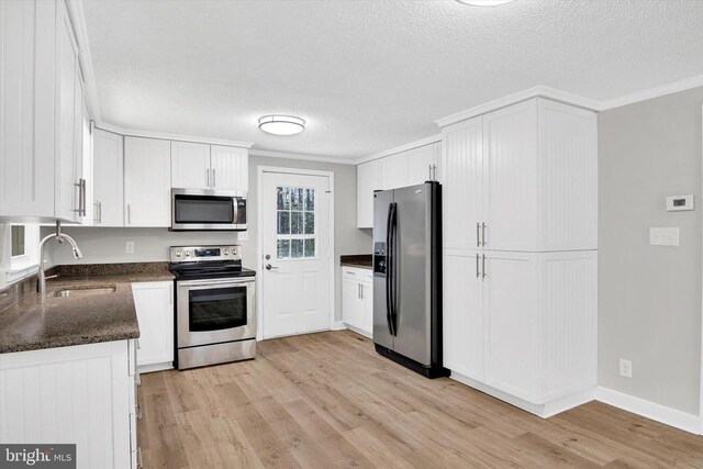 kitchen featuring white cabinetry, stainless steel appliances, and light hardwood / wood-style floors