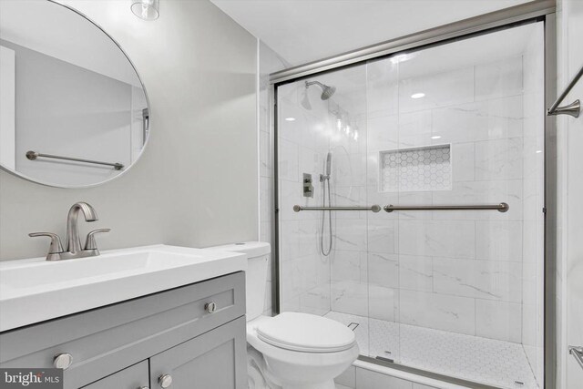 bathroom featuring walk in shower, vanity, and toilet