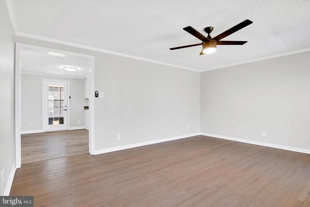 empty room with dark wood-type flooring and ornamental molding