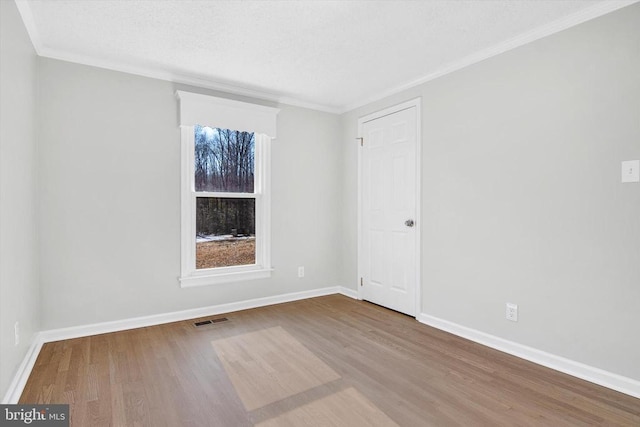 unfurnished room with hardwood / wood-style flooring and crown molding