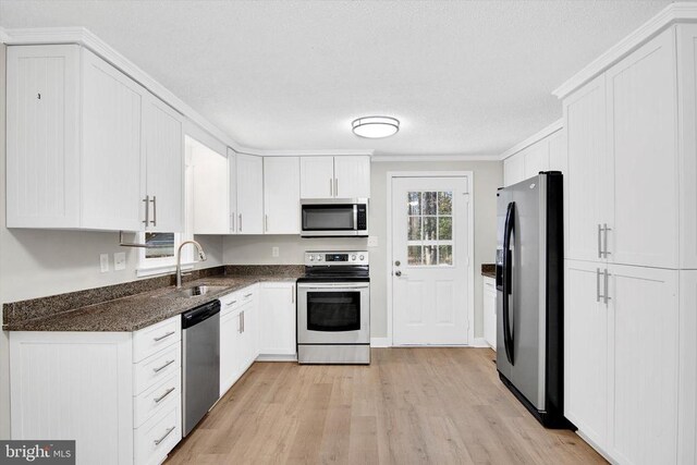 kitchen with stainless steel appliances, sink, and white cabinets