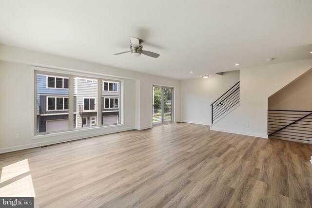 unfurnished living room with ceiling fan and light wood-type flooring