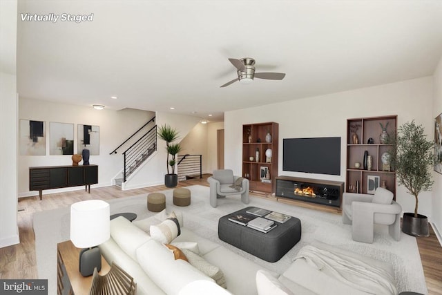 living room featuring ceiling fan and light hardwood / wood-style floors