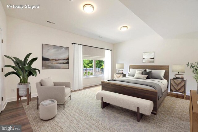 bedroom with wood-type flooring and vaulted ceiling