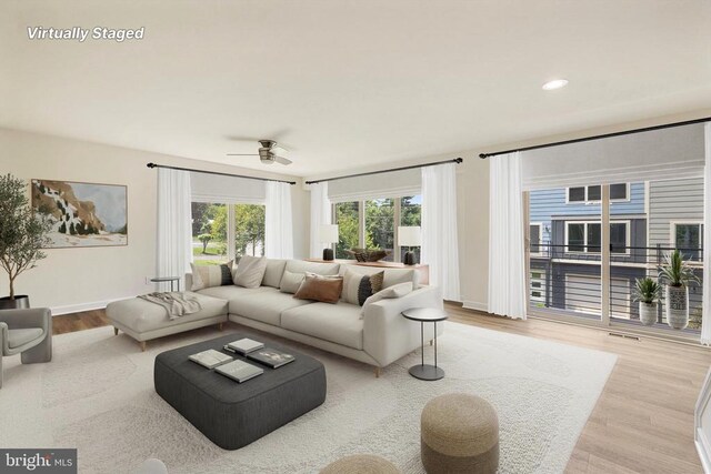 living room featuring ceiling fan and light hardwood / wood-style floors